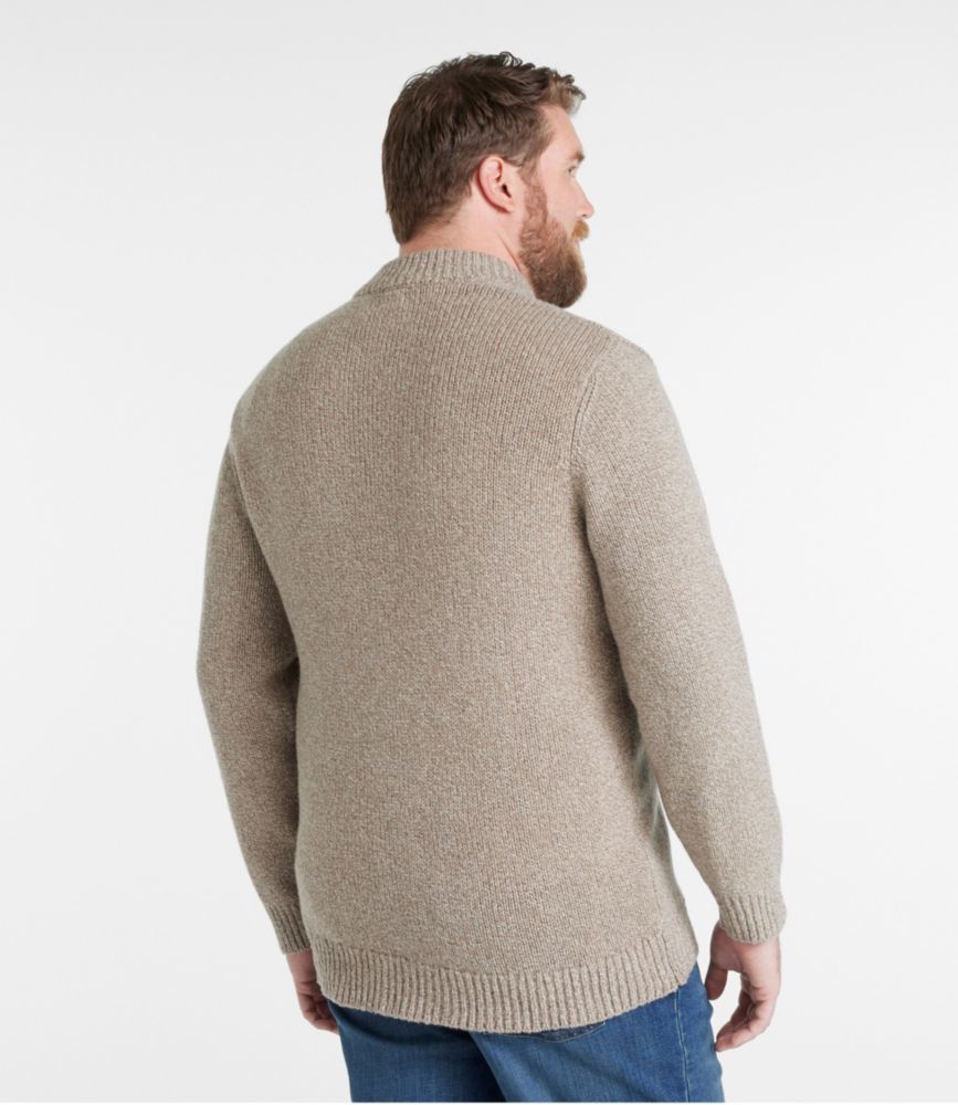 Back view of a man wearing a natural tan ragg wool Henley sweater with ribbed hem and cuffs over jeans.