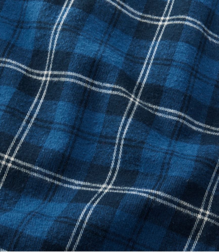 Close-up of blue and navy plaid flannel fabric with white tartan stripes.