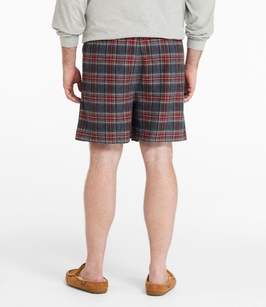 Back view of men’s gray and red plaid flannel boxer shorts worn with slippers.