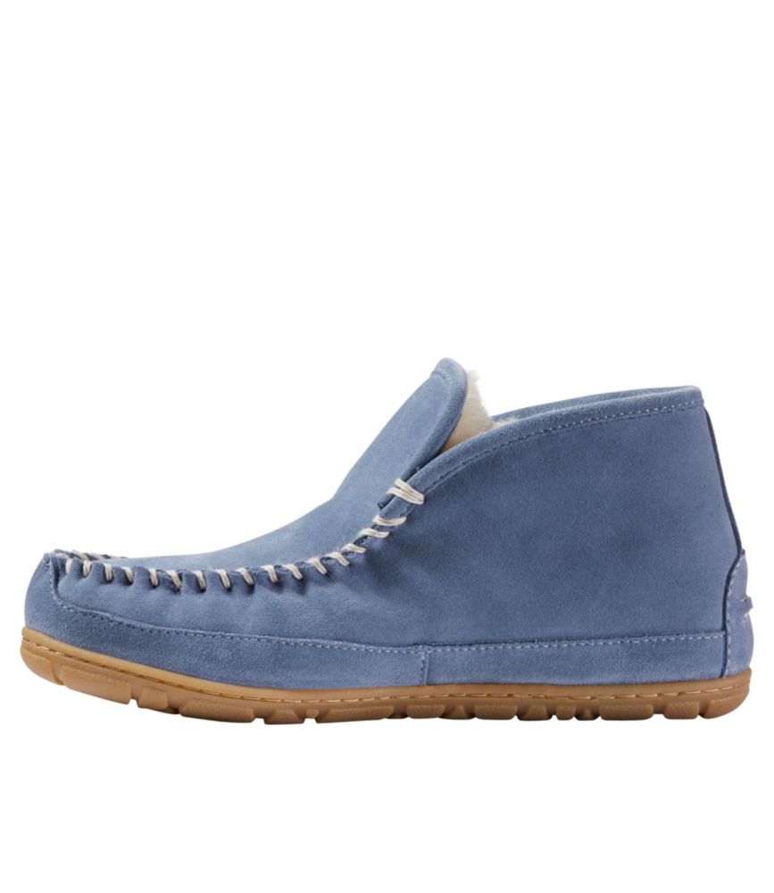 Women’s charcoal blue suede slipper boot moc with shearling lining and tan rubber sole, shown from side view.