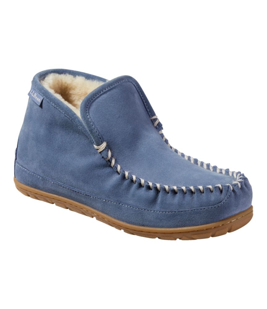 Women’s blue suede boot moc slipper with shearling lining, contrast whipstitching, and brown rubber sole, angled side view.
