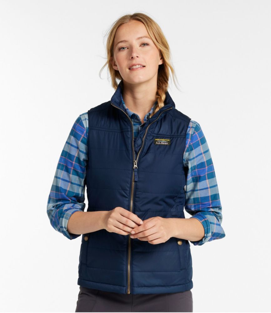Woman wearing a nautical navy quilted puffer vest over a blue plaid shirt, shown from the front.