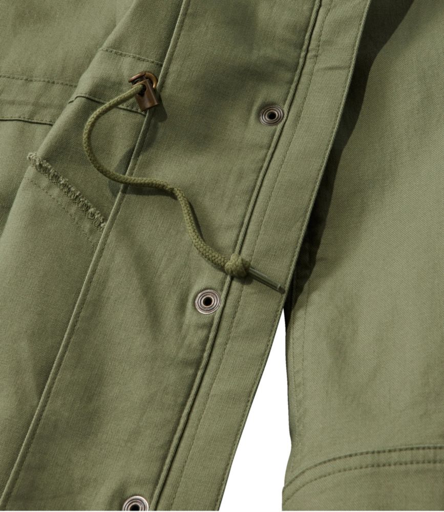 Olive green women’s utility jacket close-up showing canvas fabric, grommets, and adjustable drawcord waist detail.