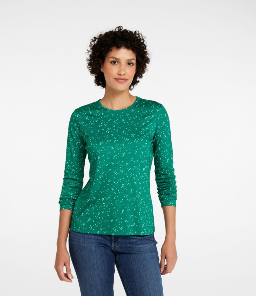 Woman wearing a forest green scatter dot long-sleeve crewneck tee with slim fit, paired with blue jeans.