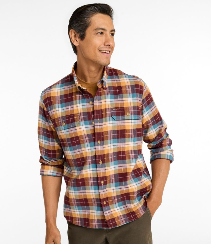 Men’s long-sleeve hemp-blend plaid shirt in burgundy, mustard, and teal, worn untucked with sleeves rolled up.