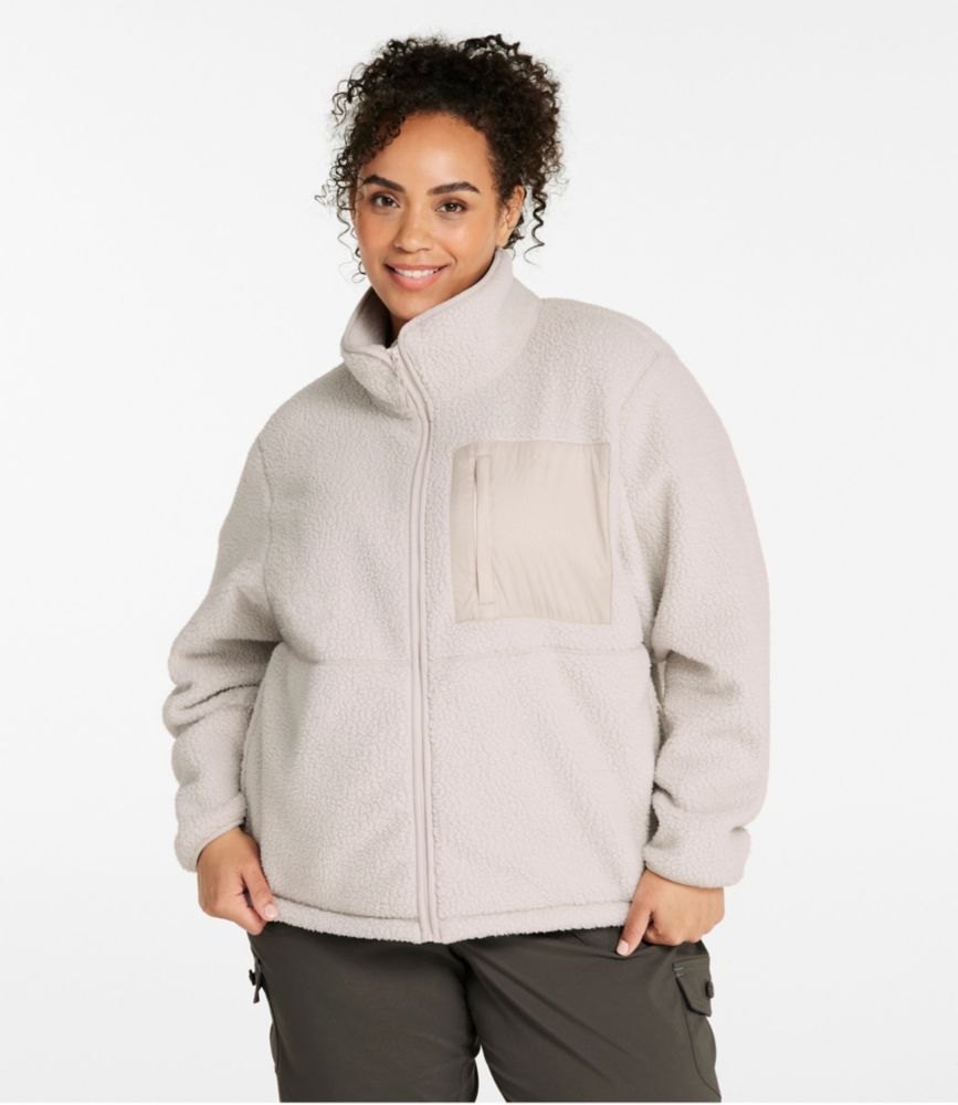Women’s light beige sherpa fleece jacket with zip front and contrast chest pocket, shown worn with dark pants.
