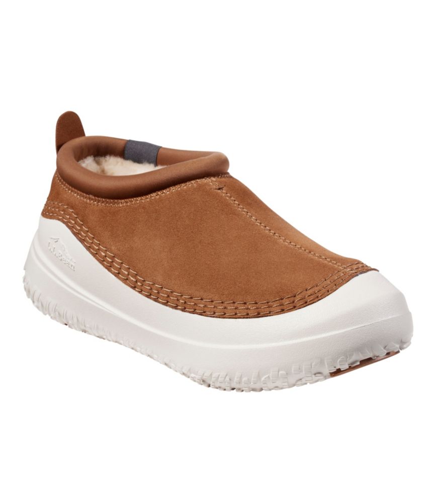 Women’s tan suede slip-on slipper with white rubber outsole and plush fleece lining, shown at a side angle.