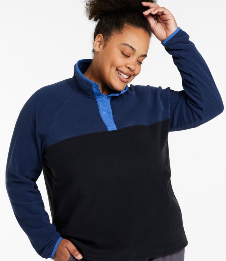 Woman wearing a navy and black colorblock fleece pullover with a blue snap half placket, shown from the front.