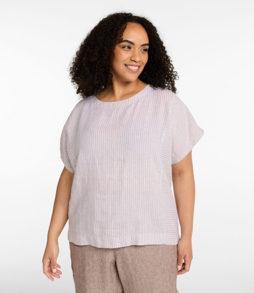 Women’s short-sleeve striped linen boatneck shirt in soft sand tones, worn untucked with linen pants.