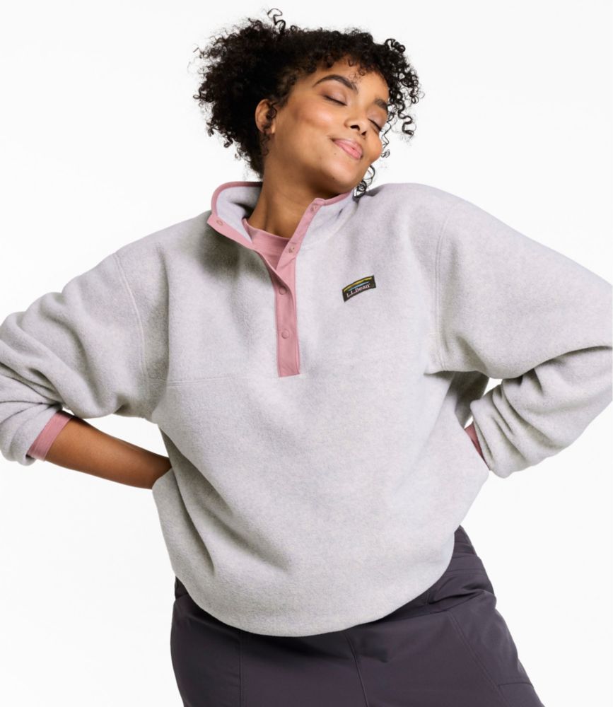 Women’s light gray fleece pullover with pink snap placket and stand collar, shown worn from the front.